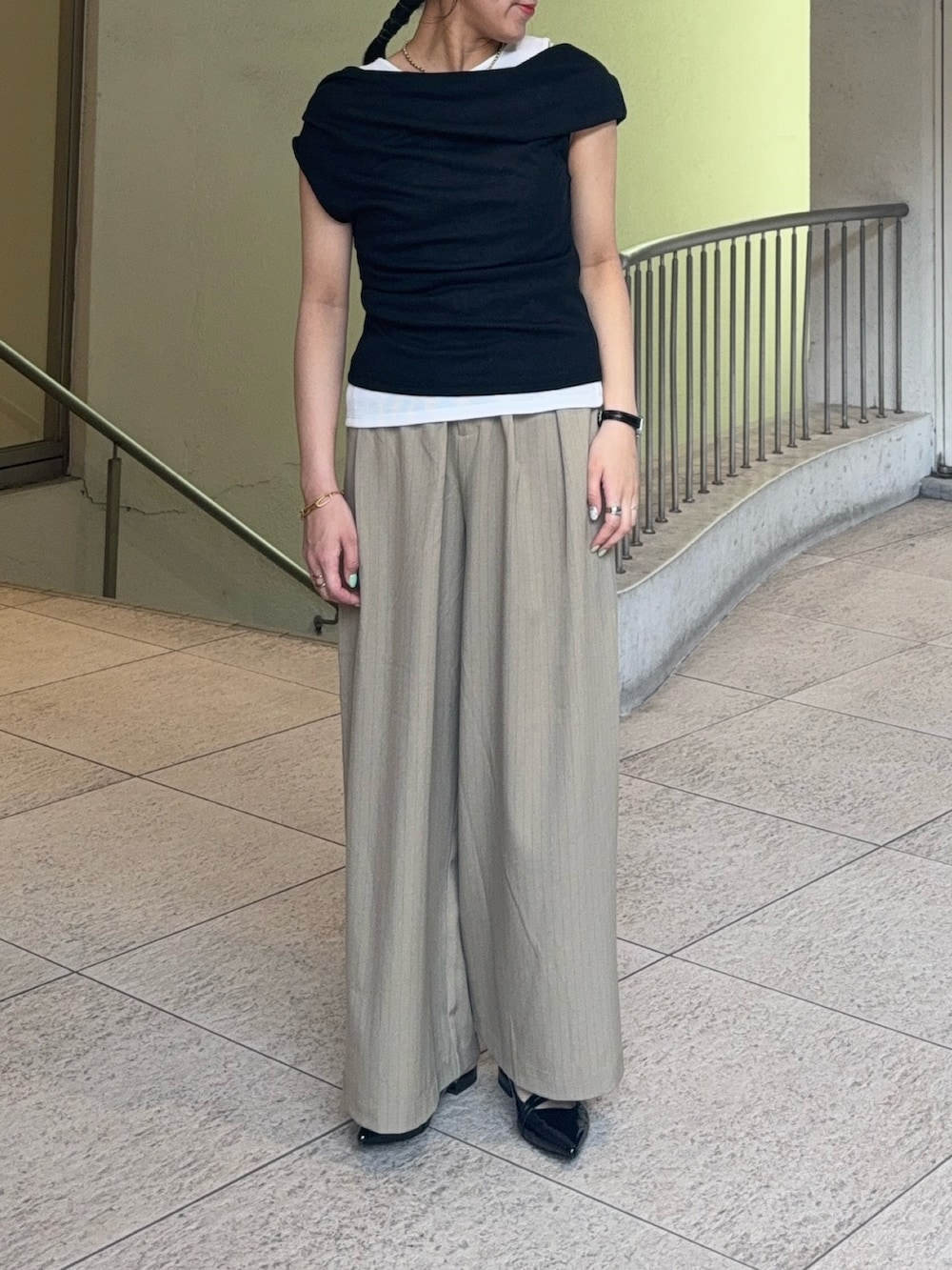 ブラック系のタンクトップ、ベージュ系のスラックス、ブラック系のパンプスを着用したレディースの夏コーディネートの2枚目の写真