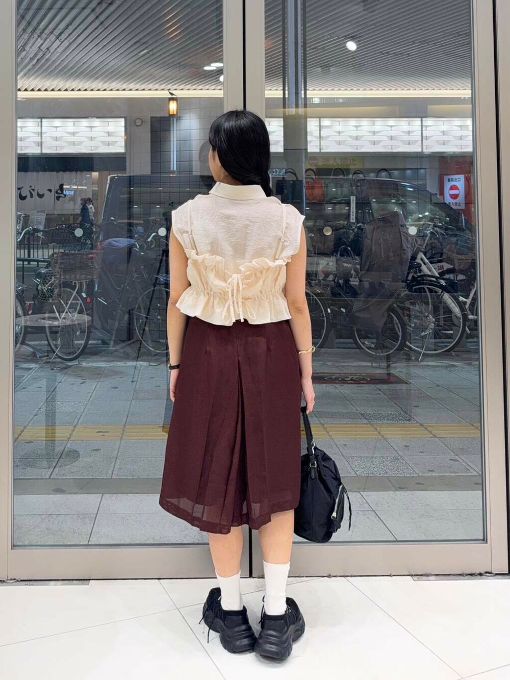 ブラック系のスニーカー、ホワイト系のキャミソール、ホワイト系のシャツ/ブラウスを着用したレディースの夏コーディネートの3枚目の写真