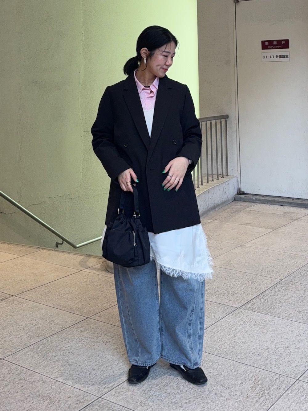 ホワイト系のキャミソール、ブルー系のデニムパンツ、ブラック系のテーラードジャケットを着用したレディースの春コーディネートの2枚目の写真