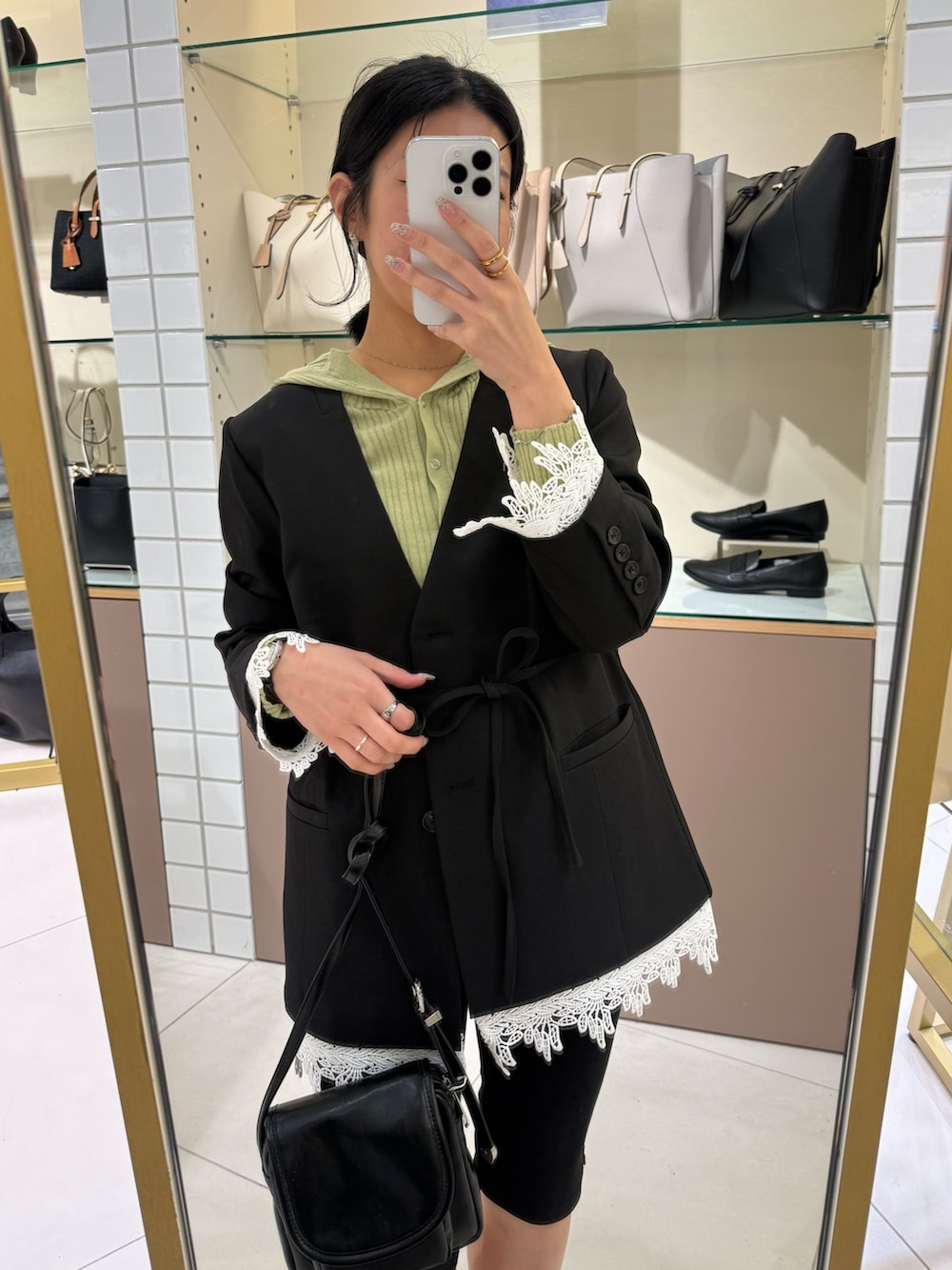 ブラック系のノーカラージャケット、ベージュ系のニット/セーター、ブラック系のその他パンツを着用したレディースの春コーディネートの4枚目の写真