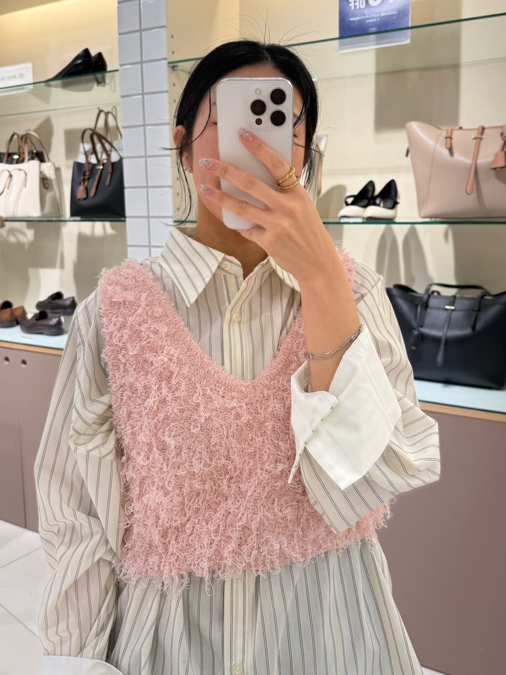 ホワイト系のシャツ/ブラウス、ピンク系のベスト、ブラウン系のハンドバッグを着用したレディースの冬コーディネートの4枚目の写真