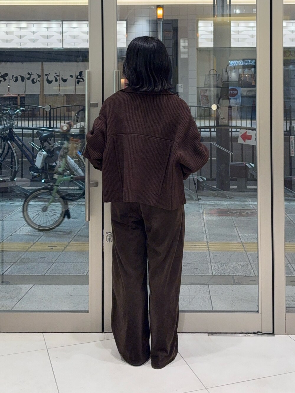 ブラウン系のその他アウター、ブラウン系のその他パンツ、ブラック系のニット/セーターを着用したレディースの秋コーディネートの2枚目の写真