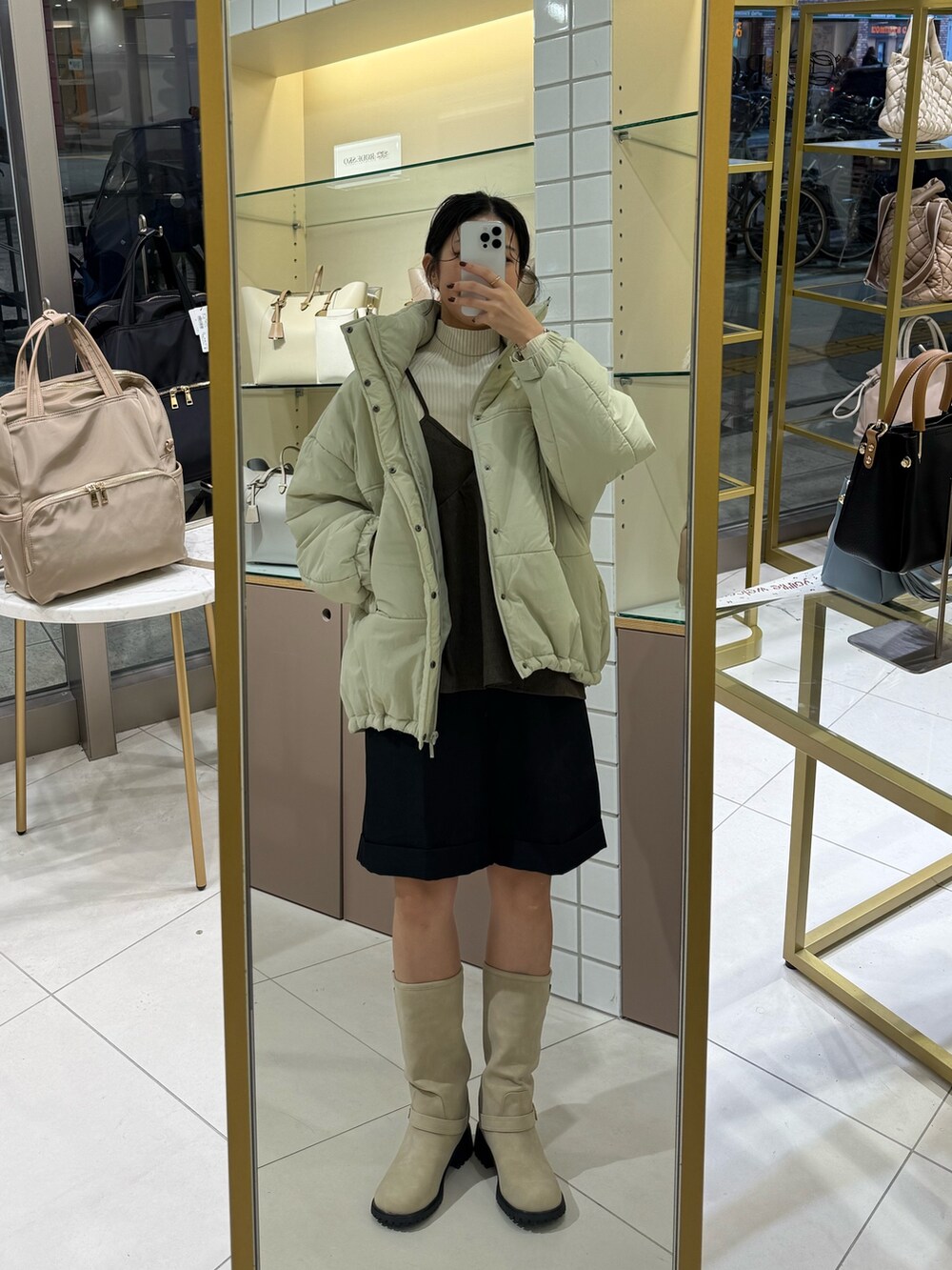 ベージュ系のブーツ、ブラック系のその他パンツ、ホワイト系のニット/セーターを着用したレディースの秋コーディネートの5枚目の写真