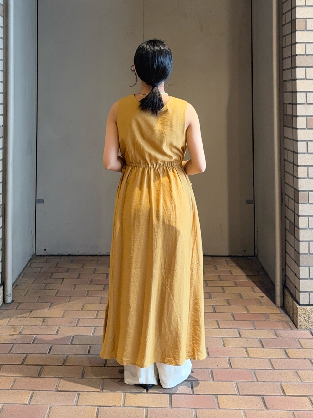 ブラック系のキャミソール、ブラック系のサンダル、ホワイト系のその他パンツを着用したレディースの春コーディネートの3枚目の写真