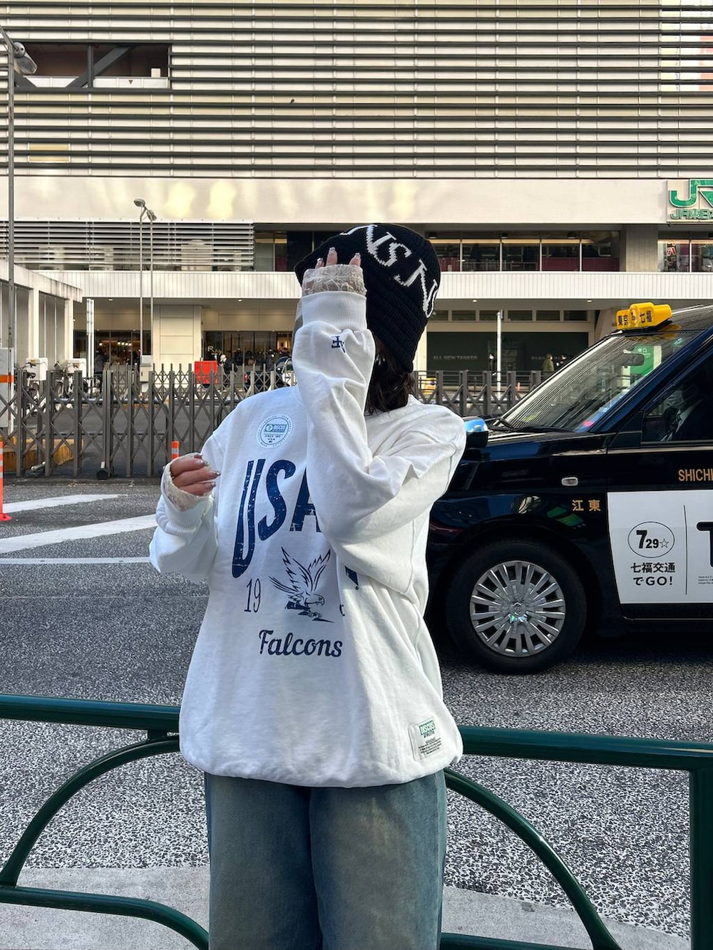 ブルー系のデニムパンツ、ホワイト系のスウェット、ブラック系のハットを着用したレディースの冬コーディネートの3枚目の写真