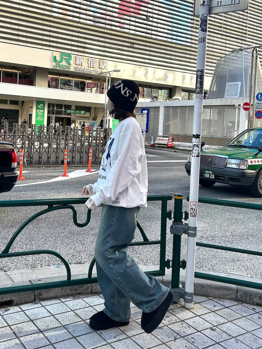 ブルー系のデニムパンツ、ホワイト系のスウェット、ブラック系のハットを着用したレディースの冬コーディネートの2枚目の写真