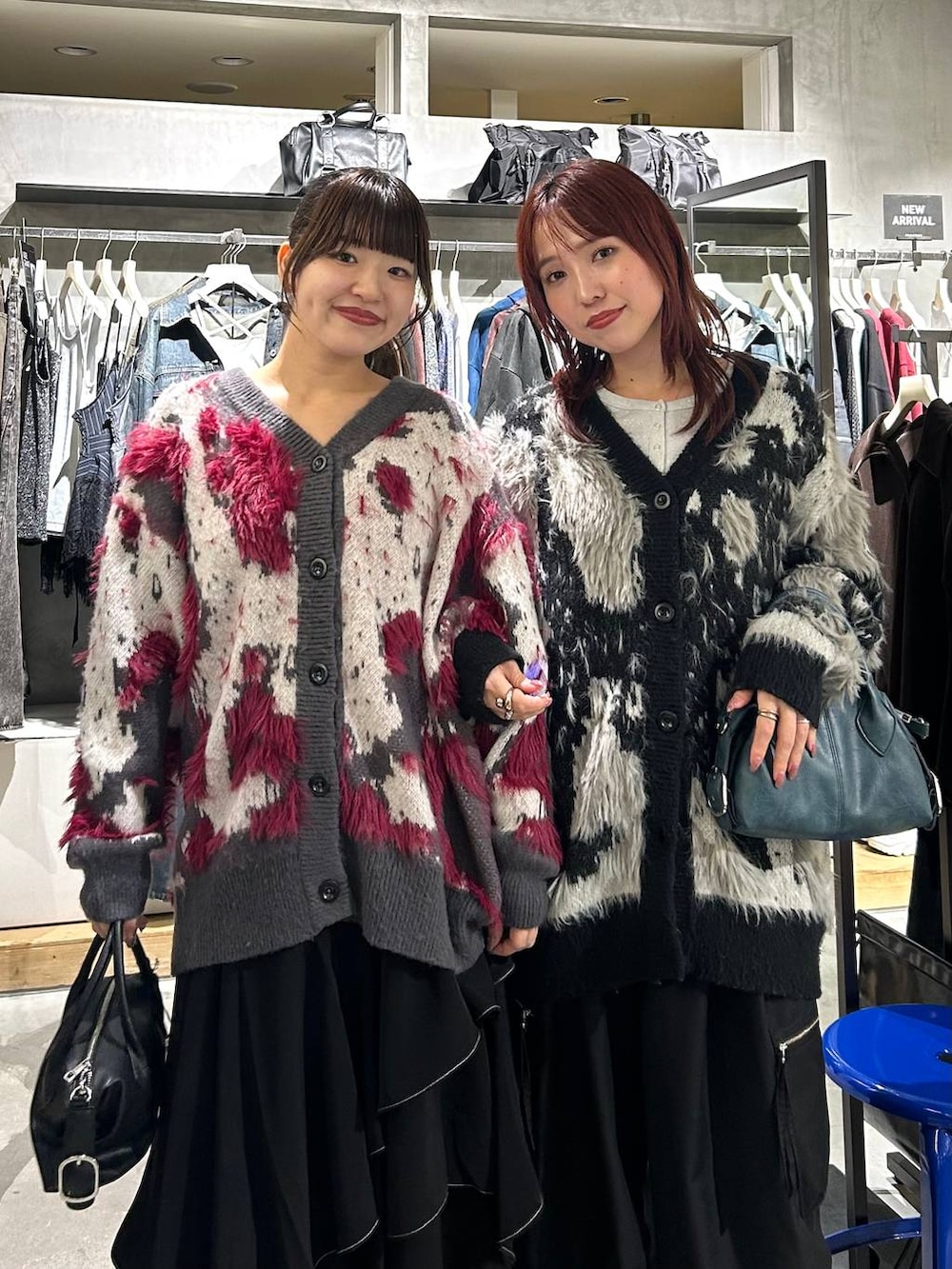 ブラック系のカーゴパンツ、ブラック系のスカート、ブルー系のショルダーバッグを着用したレディースの秋コーディネートの2枚目の写真
