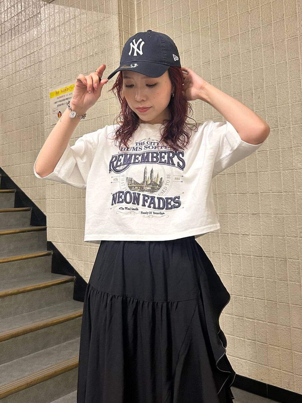 ブラック系のブーツ、ブラック系のスカート、ホワイト系のTシャツ/カットソーを着用したレディースの夏コーディネートの5枚目の写真