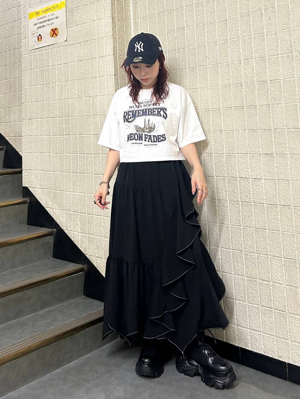 ブラック系のブーツ、ブラック系のスカート、ホワイト系のTシャツ/カットソーを着用したレディースの夏コーディネートの2枚目の写真