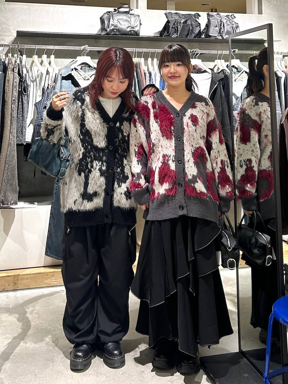 ブラック系のカーゴパンツ、ブラック系のスカート、ブルー系のショルダーバッグを着用したレディースの秋コーディネートの5枚目の写真