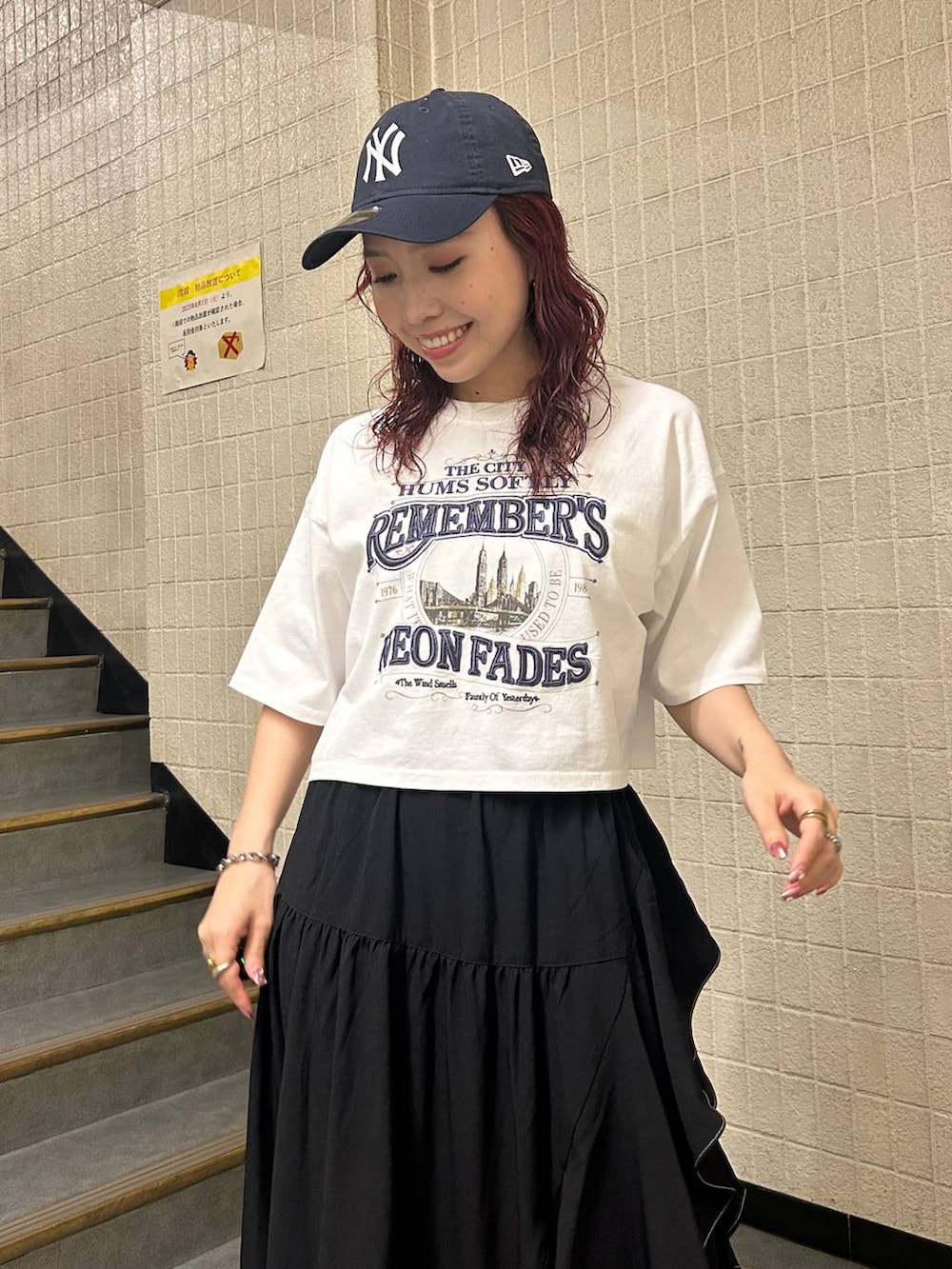 ブラック系のブーツ、ブラック系のスカート、ホワイト系のTシャツ/カットソーを着用したレディースの夏コーディネートの6枚目の写真