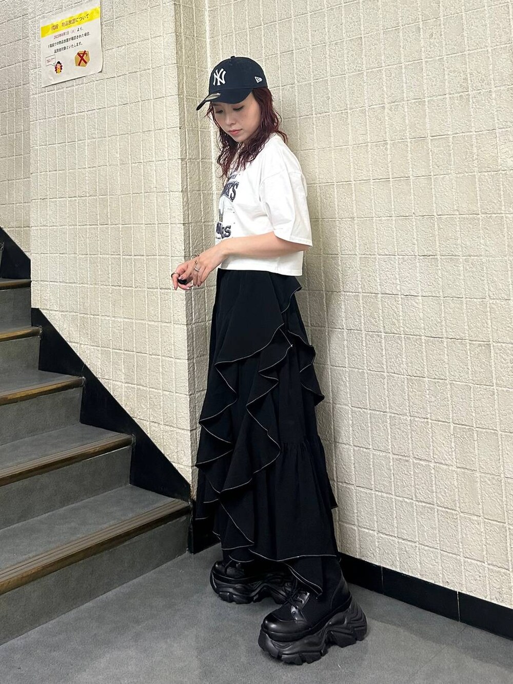 ブラック系のブーツ、ブラック系のスカート、ホワイト系のTシャツ/カットソーを着用したレディースの夏コーディネートの3枚目の写真