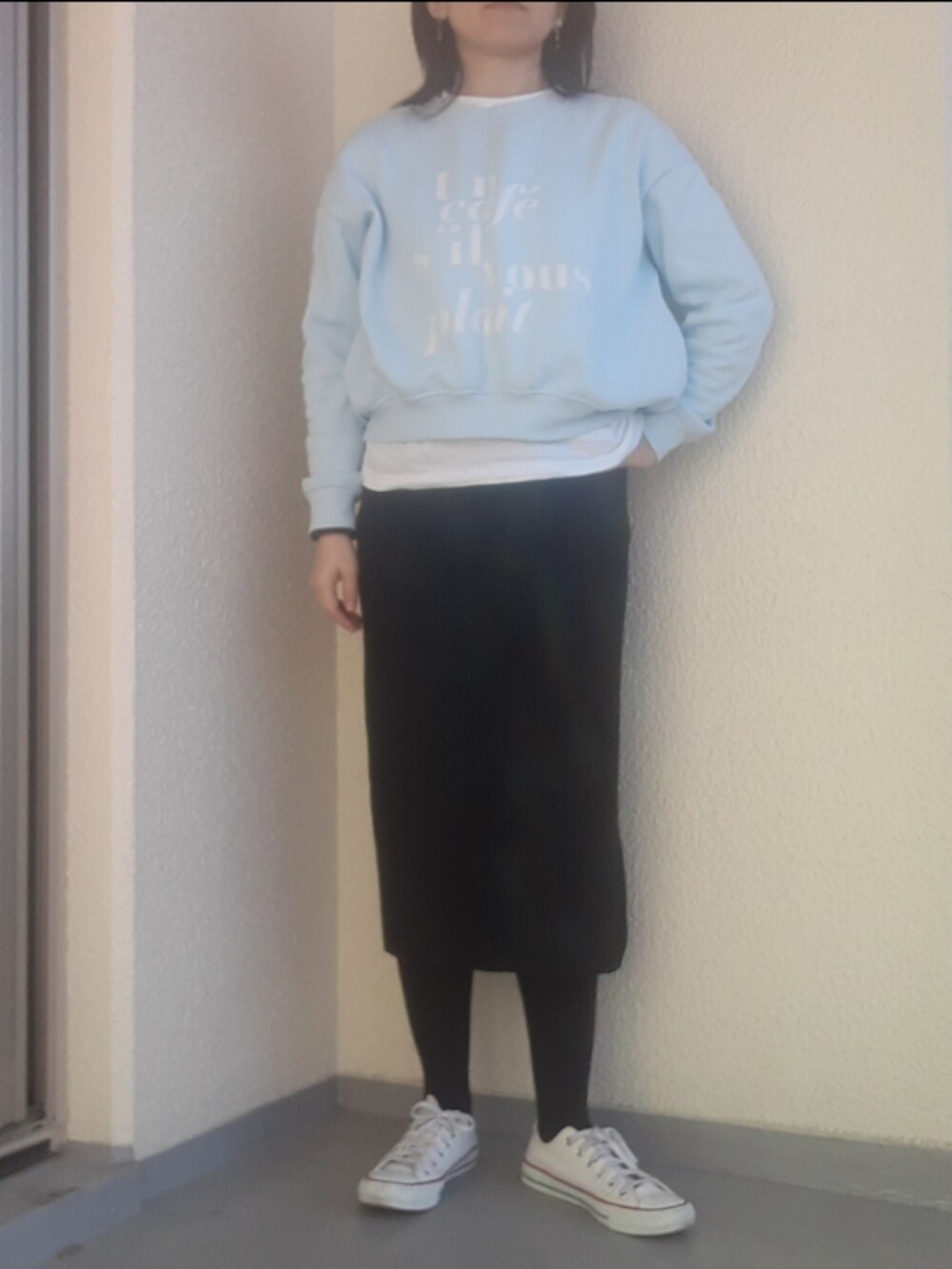 ホワイト系のスニーカー、ブラック系のチェスターコート、ブルー系のスウェットを着用したレディースの春コーディネートの2枚目の写真