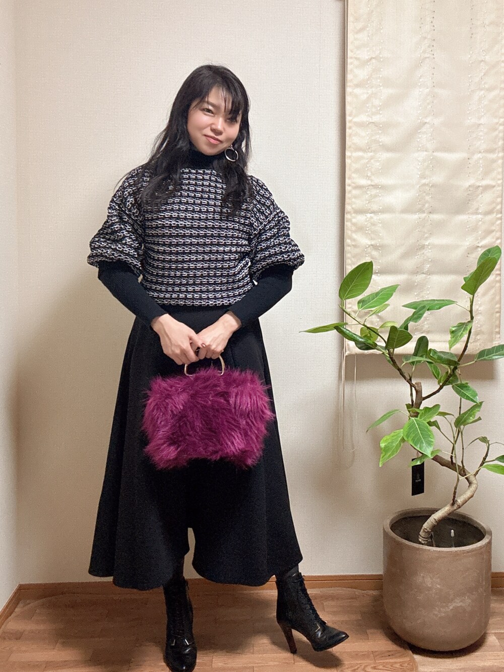 ブラック系のスカート、ブラック系のニット/セーターを着用したレディースの冬コーディネートの2枚目の写真