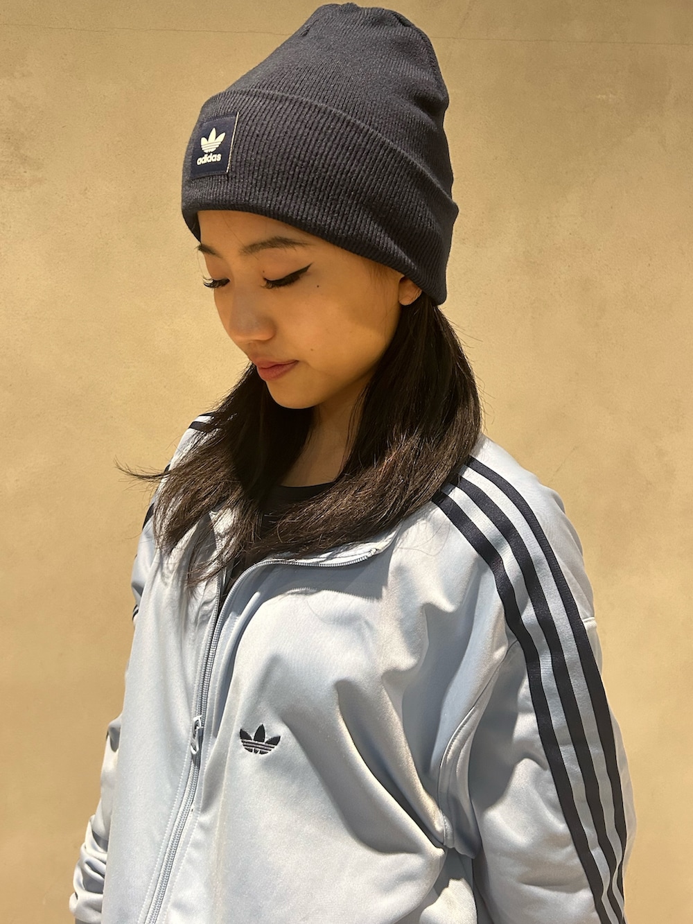 ブルー系のジャージ、ブラック系のスニーカー、ブルー系のニットキャップ/ビーニーを着用したレディースの秋コーディネートの3枚目の写真