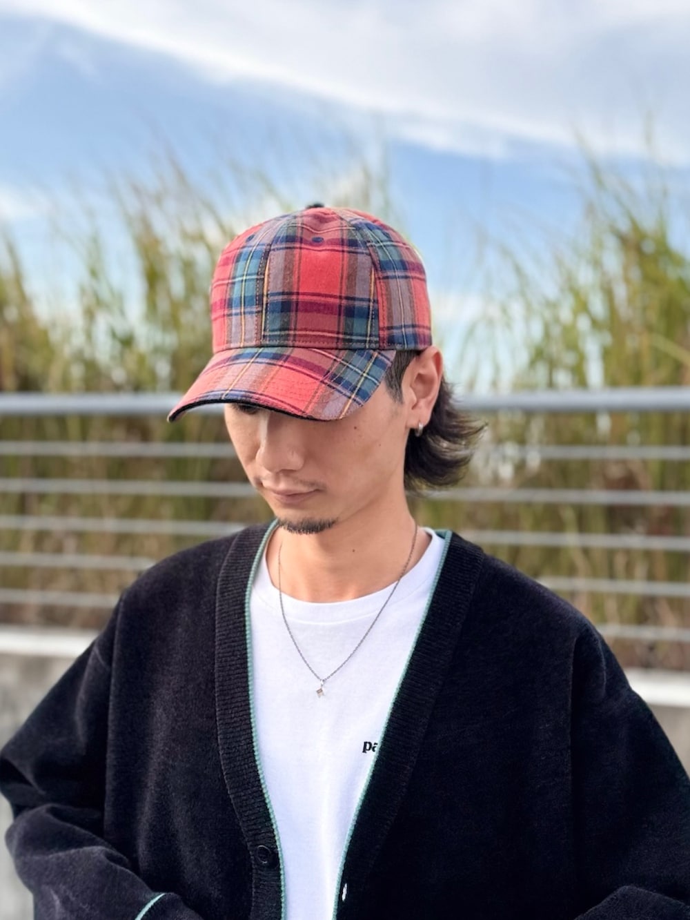 レッド系のキャップを着用したメンズの秋コーディネートの3枚目の写真