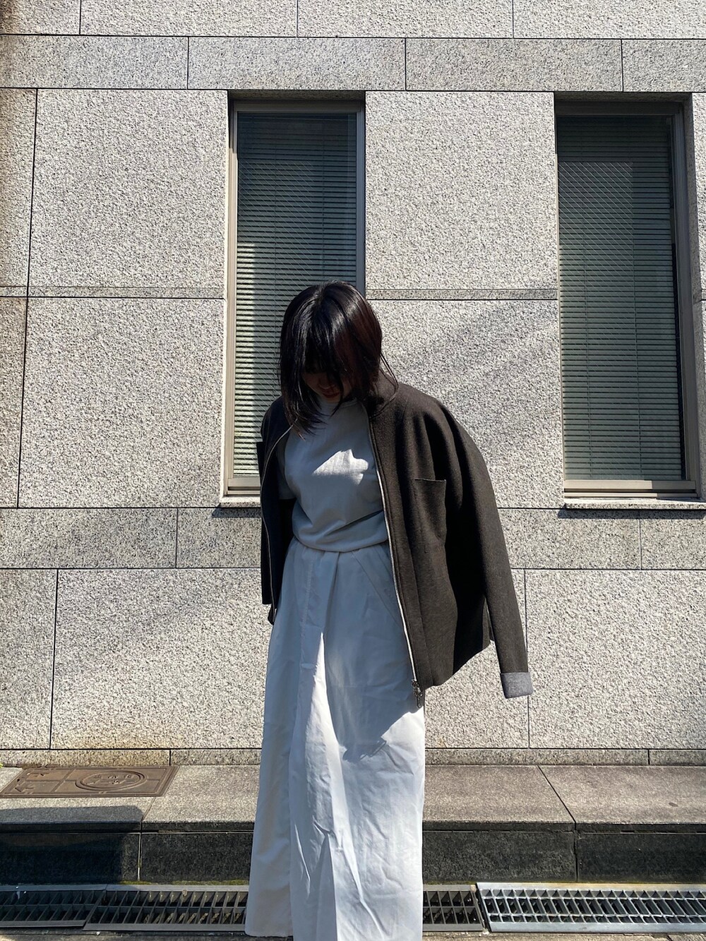 ホワイト系のTシャツ/カットソー、ホワイト系のスカート、ブルー系のデニムパンツを着用したレディースの春コーディネートの2枚目の写真