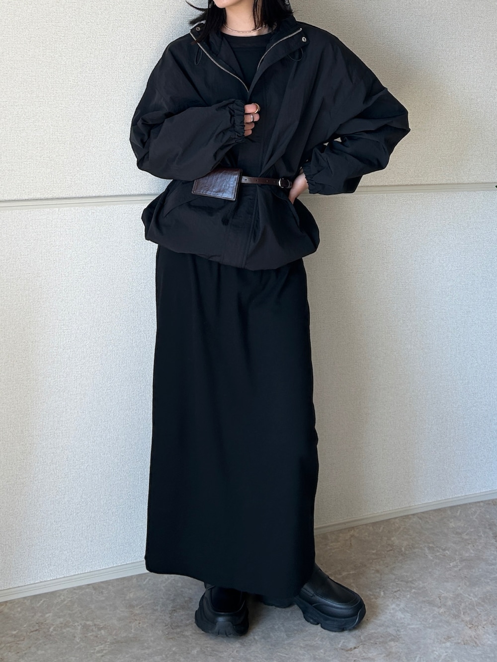 ブラック系のローファー、ブラック系のナイロンジャケット、ブラック系のワンピースを着用したレディースの春コーディネートの3枚目の写真