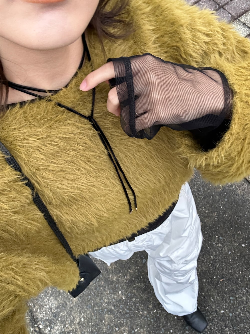 グリーン系のニット/セーター、ブラック系のTシャツ/カットソー、ホワイト系のカーゴパンツを着用したレディースの冬コーディネートの2枚目の写真