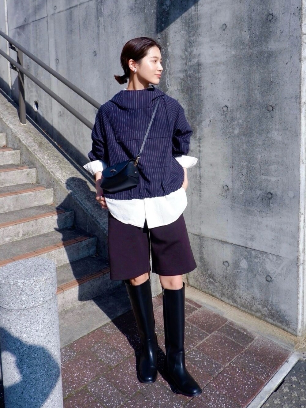 ホワイト系のシャツ/ブラウス、ブラック系のブーツ、ブラック系のショルダーバッグを着用したレディースの春コーディネートの2枚目の写真