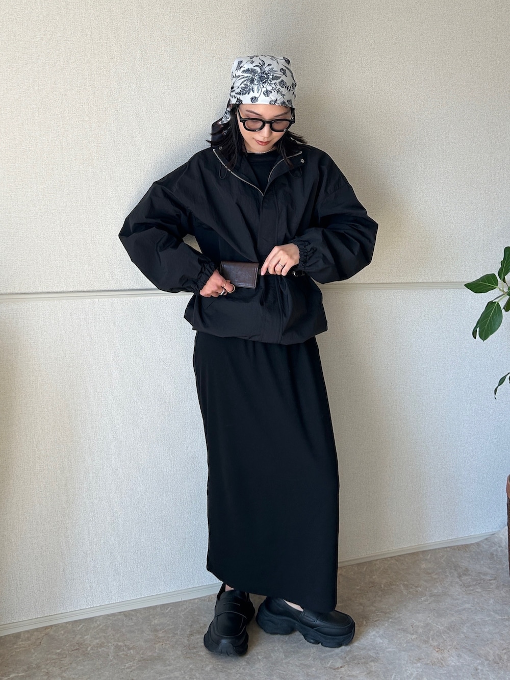 ブラック系のローファー、ブラック系のナイロンジャケット、ブラック系のワンピースを着用したレディースの春コーディネートの2枚目の写真