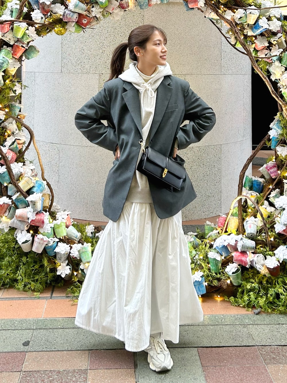 グレー系のパーカー、ホワイト系のトップス、グレー系のテーラードジャケットを着用したレディースの秋コーディネートの2枚目の写真