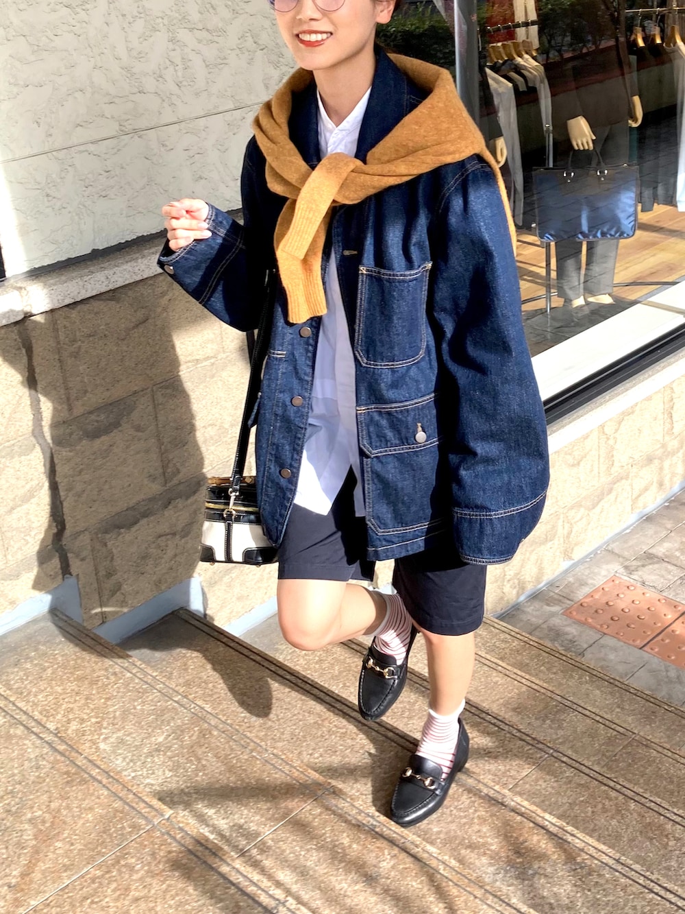 ブラック系のローファー、ブラック系のチノパンツ、ブルー系のデニムジャケットを着用したレディースの秋コーディネートの2枚目の写真