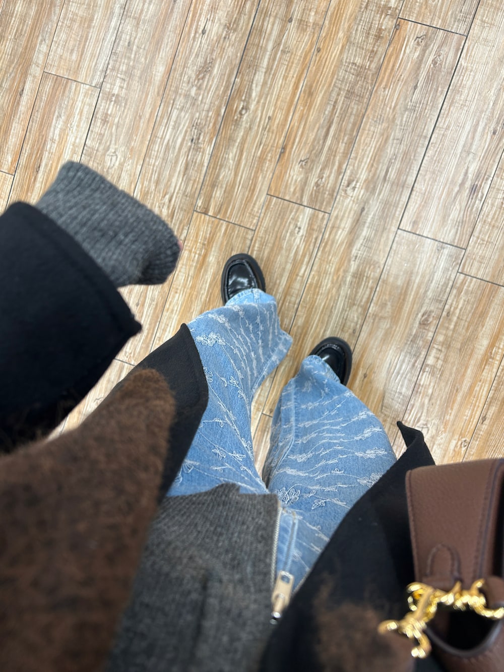 グレー系のパーカー、ブルー系のデニムパンツ、ブラック系のジャケット/アウターを着用したレディースの冬コーディネートの5枚目の写真