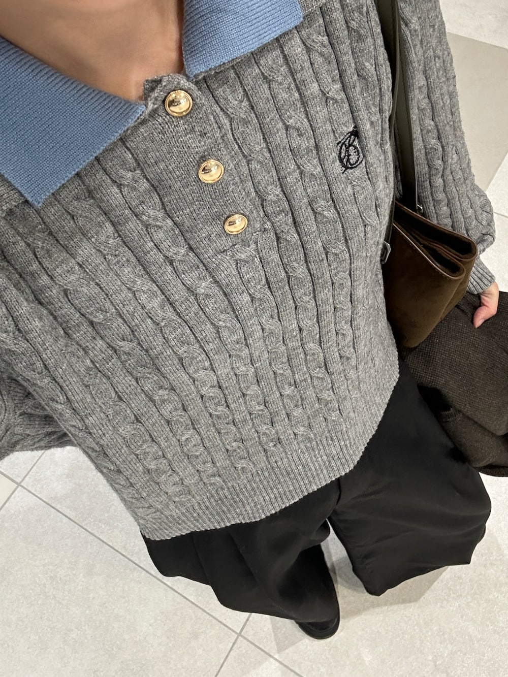 グレー系のニット/セーター、ブラウン系のテーラードジャケット、グリーン系のハンドバッグを着用したレディースの冬コーディネートの3枚目の写真