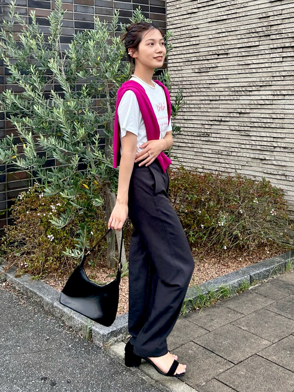 ホワイト系のTシャツ/カットソー、グレー系のパンツ、ブラック系のハンドバッグを着用したレディースの秋コーディネートの2枚目の写真