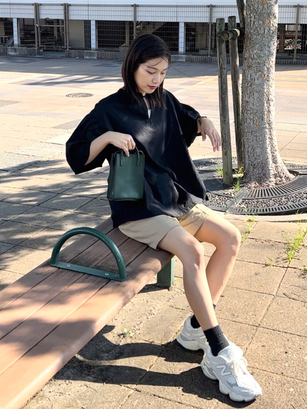 ブラック系のシャツ/ブラウス、ベージュ系のパンツ、グリーン系のショルダーバッグを着用したレディースの夏コーディネートの3枚目の写真