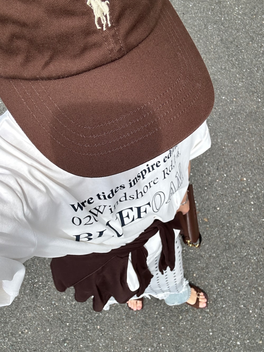 ホワイト系のスカート、ホワイト系のTシャツ/カットソー、ブルー系のデニムパンツを着用したレディースの春コーディネートの5枚目の写真