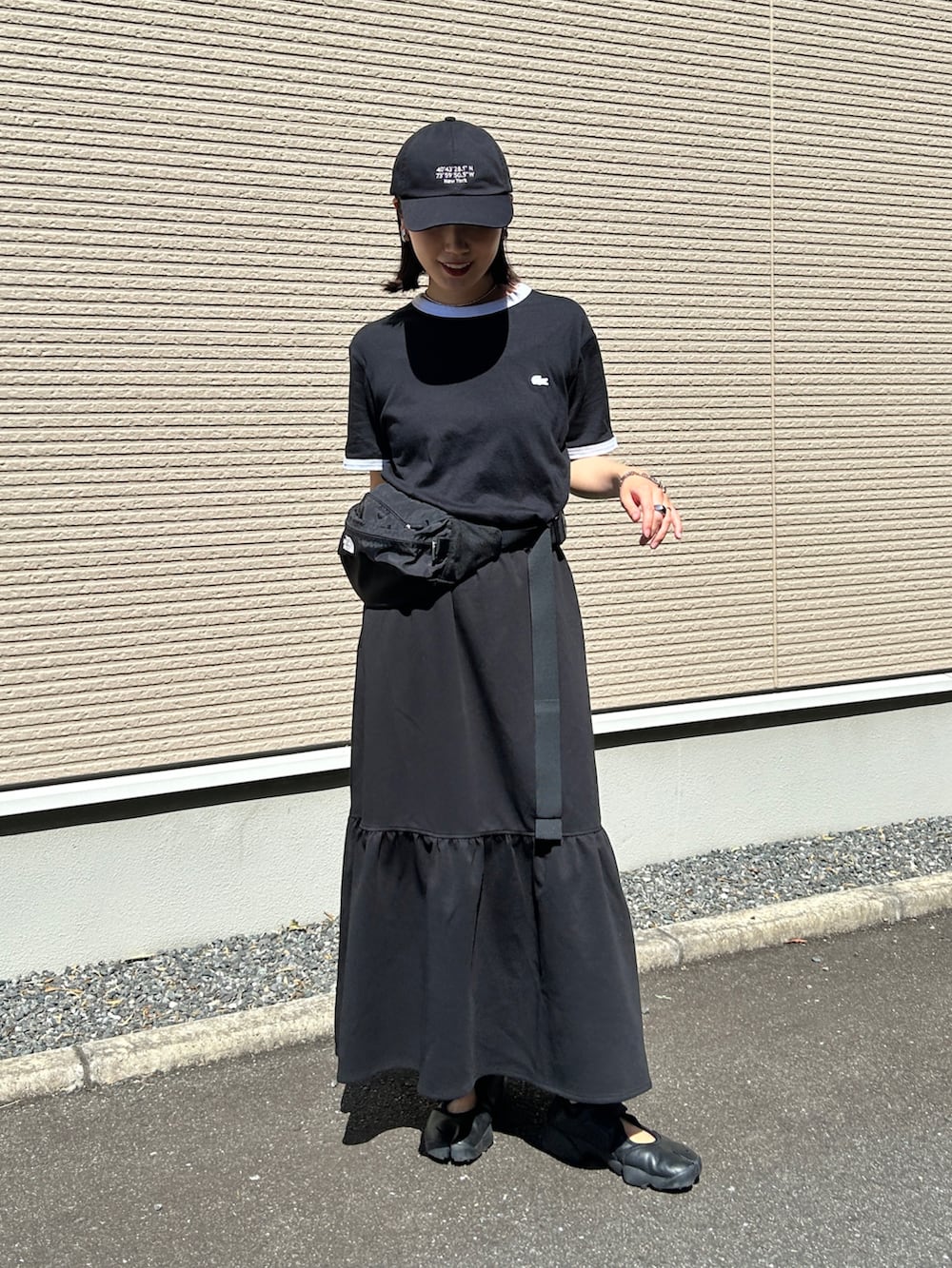 ブラック系のスニーカー、ブラック系のTシャツ/カットソー、ブラック系のスカートを着用したレディースの夏コーディネートの5枚目の写真