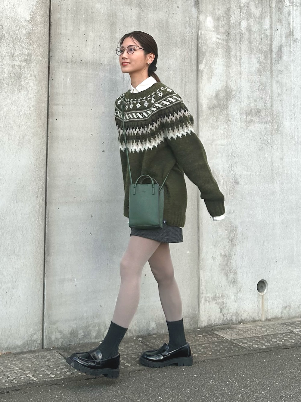 ホワイト系のシャツ/ブラウス、グリーン系のニット/セーター、ブラック系のスカートを着用したレディースの秋コーディネートの2枚目の写真