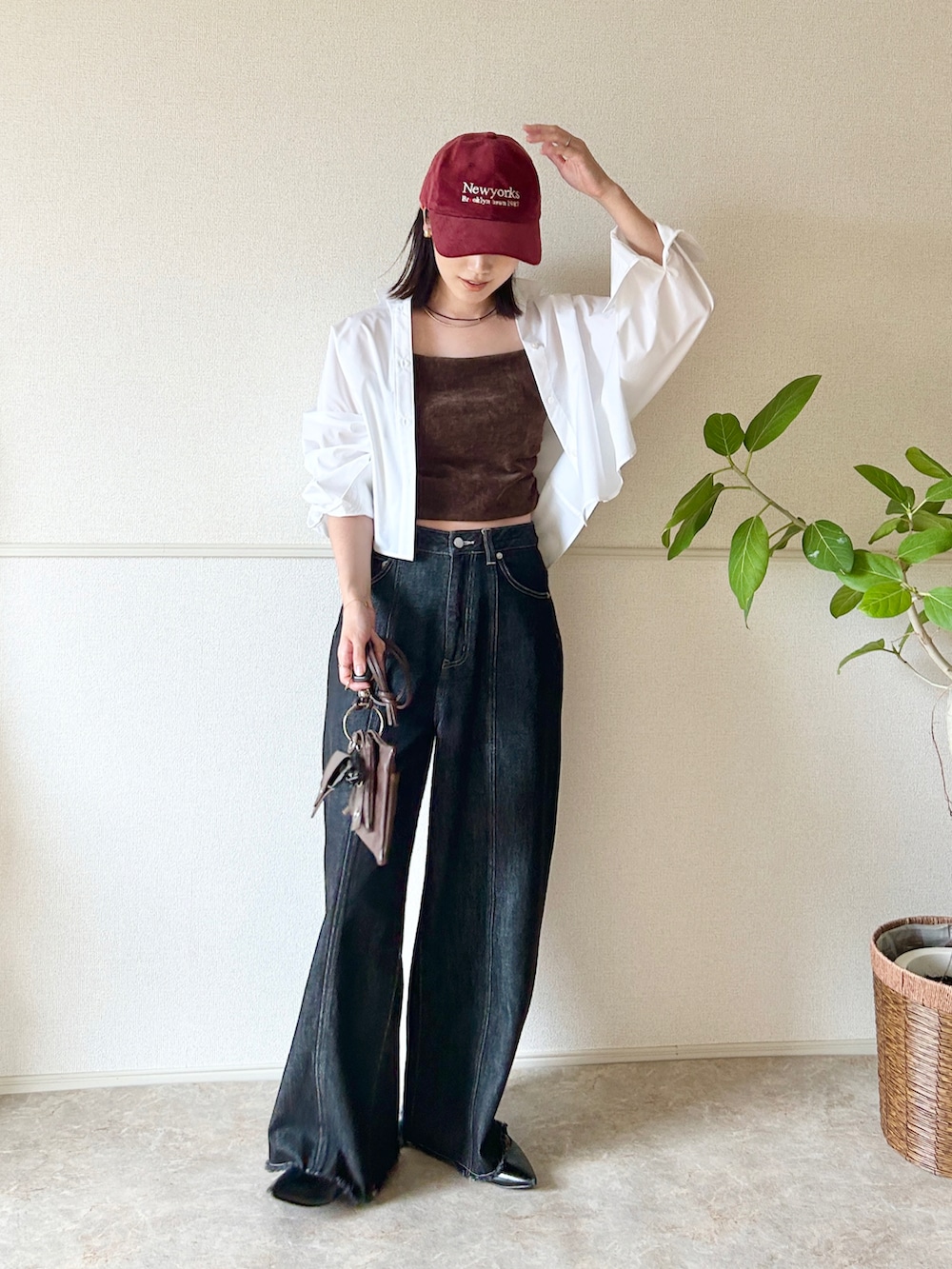 ブラック系のデニムパンツ、ブラック系のパンプス、ブラウン系のショルダーバッグを着用したレディースの秋コーディネートの3枚目の写真