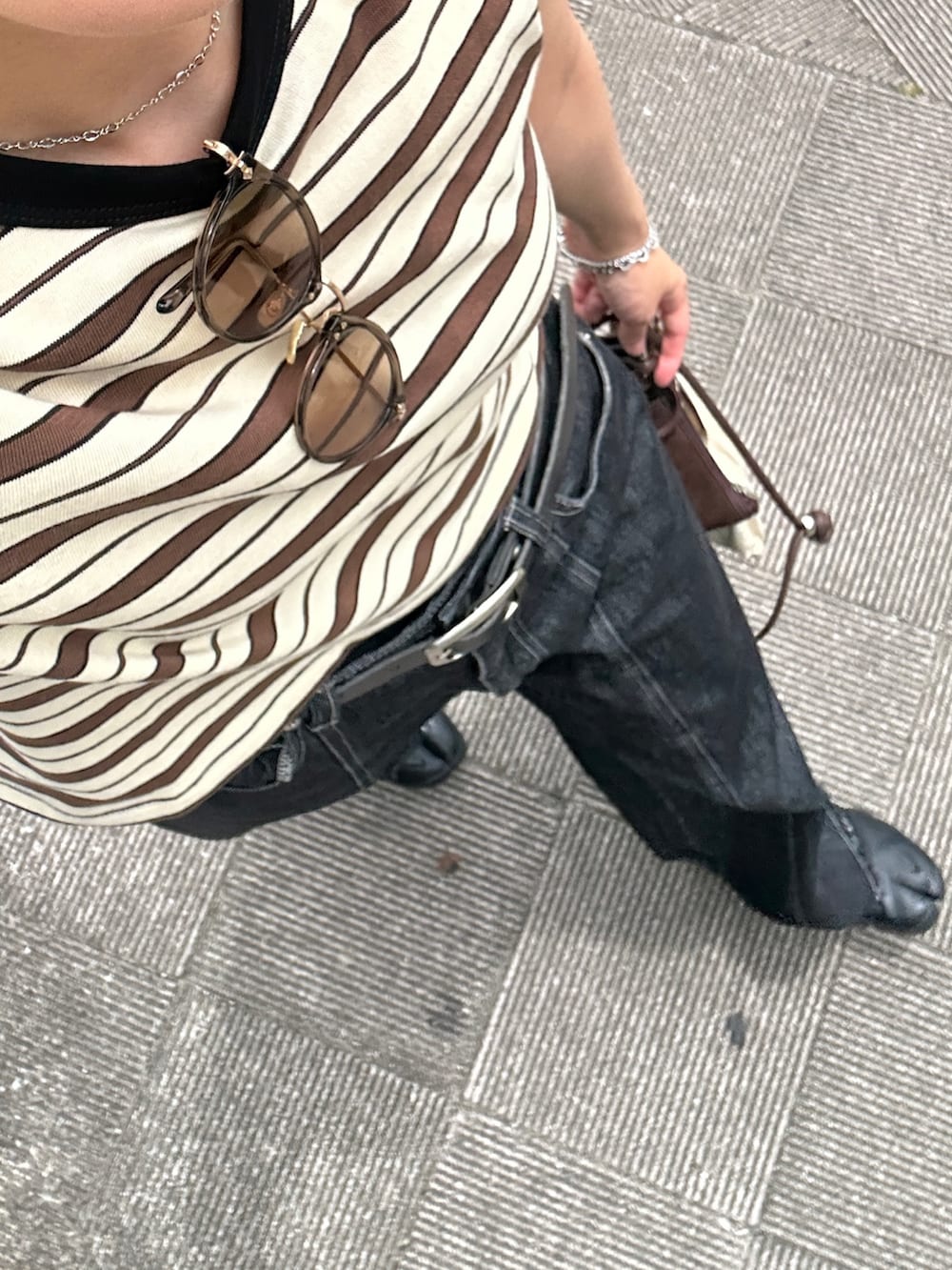 ブラック系のスニーカー、ホワイト系のTシャツ/カットソー、ブラウン系のショルダーバッグを着用したレディースの夏コーディネートの4枚目の写真