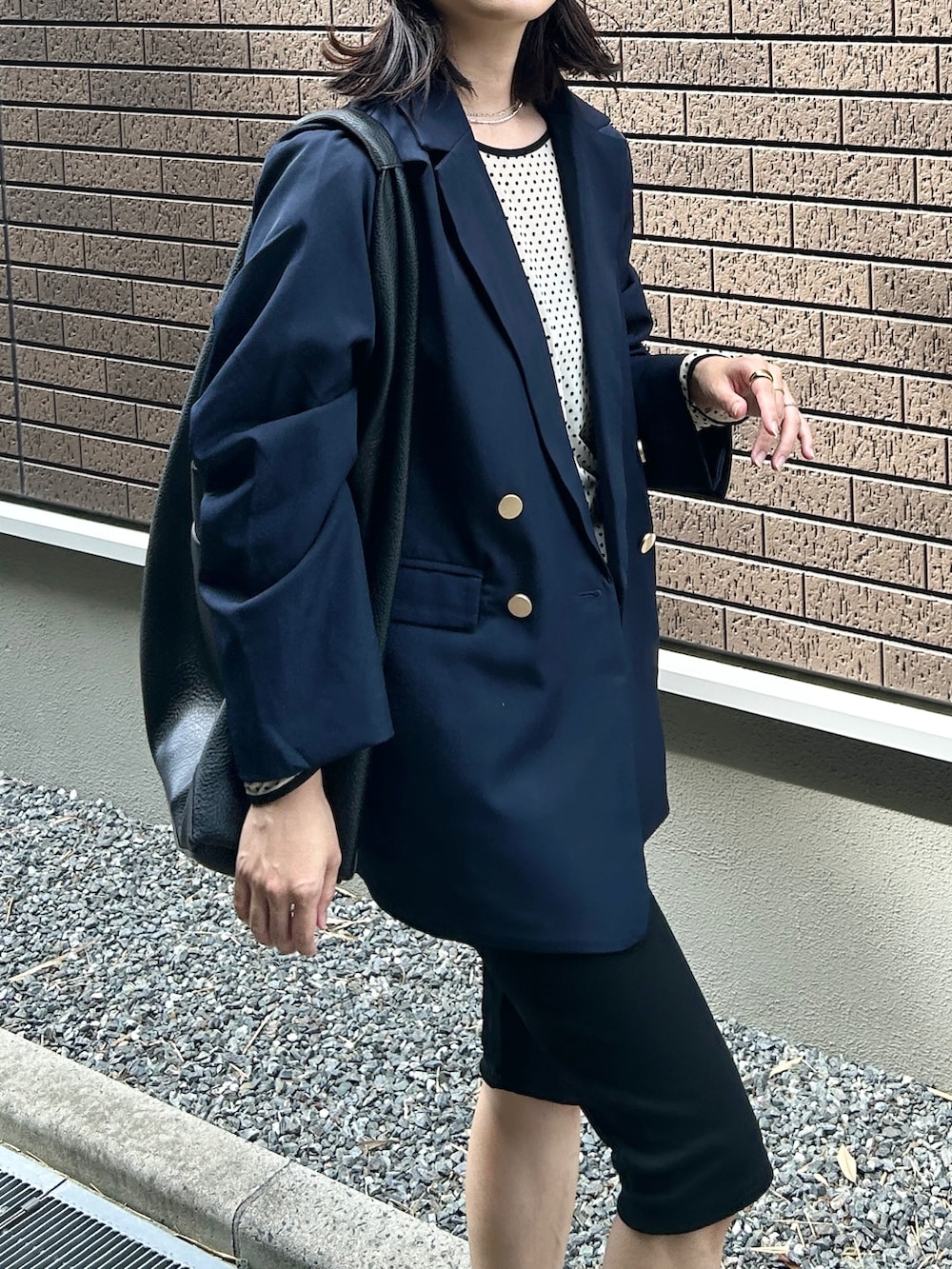 ホワイト系のTシャツ/カットソー、ブルー系のテーラードジャケット、ブラック系のその他パンツを着用したレディースの秋コーディネートの4枚目の写真