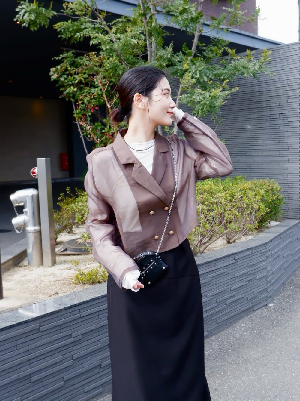 グリーン系のテーラードジャケット、ブラック系のローファー、ブラック系のスカートを着用したレディースの春コーディネートの4枚目の写真