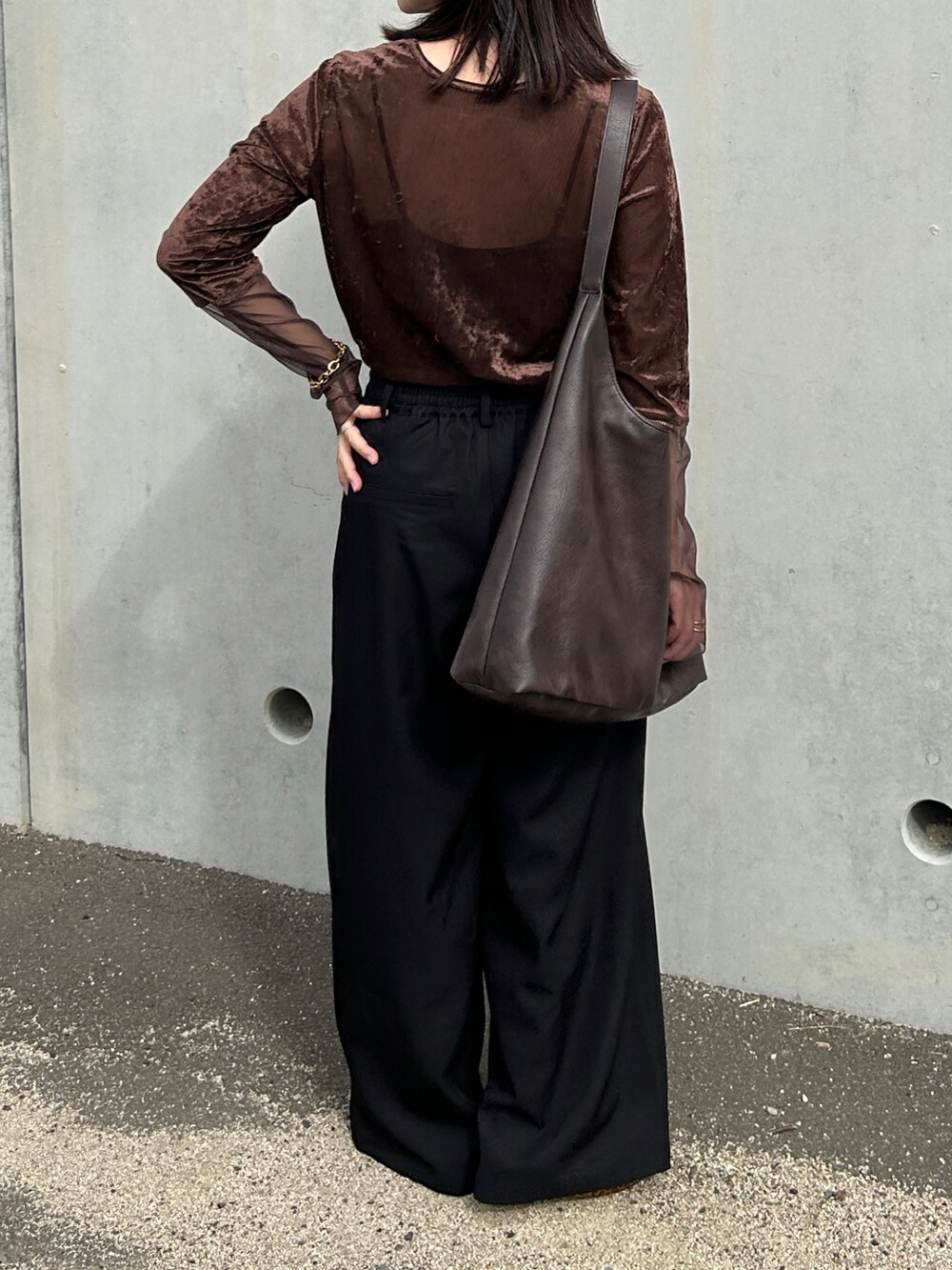 ブラック系のスラックス、ブラウン系のTシャツ/カットソー、ゴールド系のブレスレットを着用したレディースの秋コーディネートの4枚目の写真