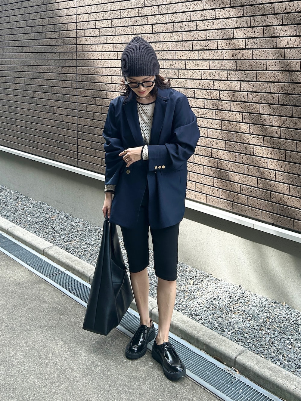 ホワイト系のTシャツ/カットソー、ブルー系のテーラードジャケット、ブラック系のその他パンツを着用したレディースの秋コーディネートの2枚目の写真