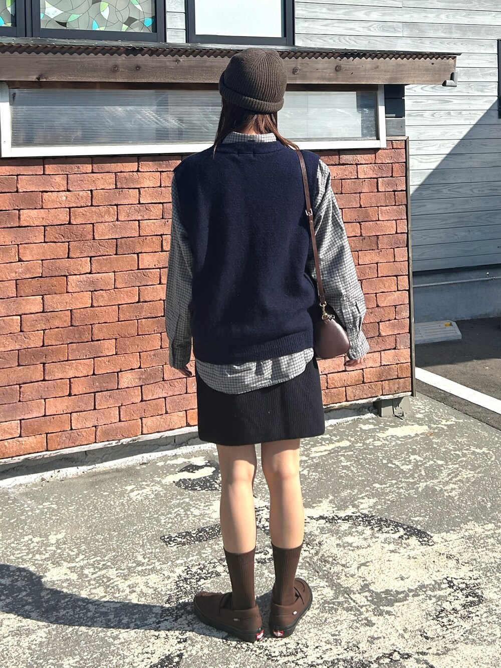 ブルー系のベスト、グレー系のシャツ/ブラウス、ブラウン系のボストンバッグを着用したレディースの秋コーディネートの5枚目の写真