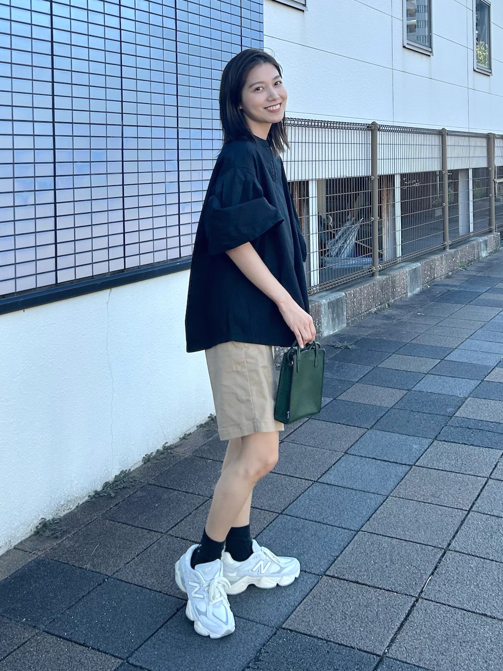 ブラック系のシャツ/ブラウス、ベージュ系のパンツ、グリーン系のショルダーバッグを着用したレディースの夏コーディネートの2枚目の写真