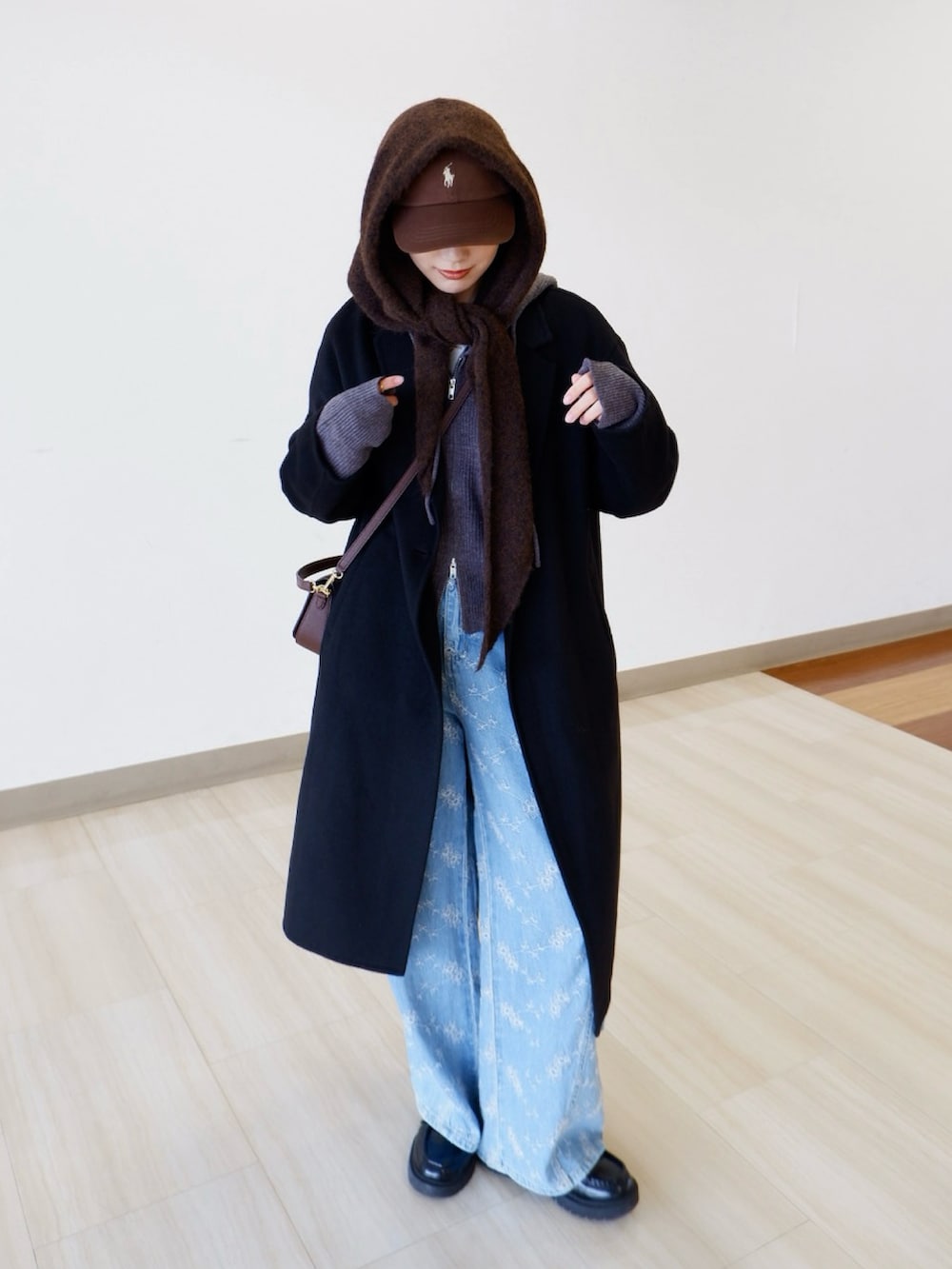 グレー系のパーカー、ブルー系のデニムパンツ、ブラック系のジャケット/アウターを着用したレディースの冬コーディネートの3枚目の写真