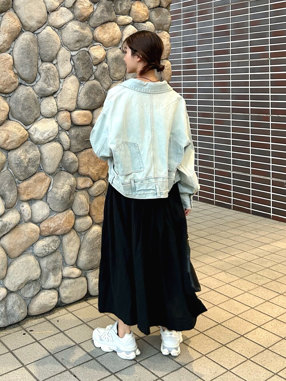 ブルー系のデニムジャケット、ホワイト系のTシャツ/カットソー、ブラック系のスカートを着用したレディースの秋コーディネートの4枚目の写真