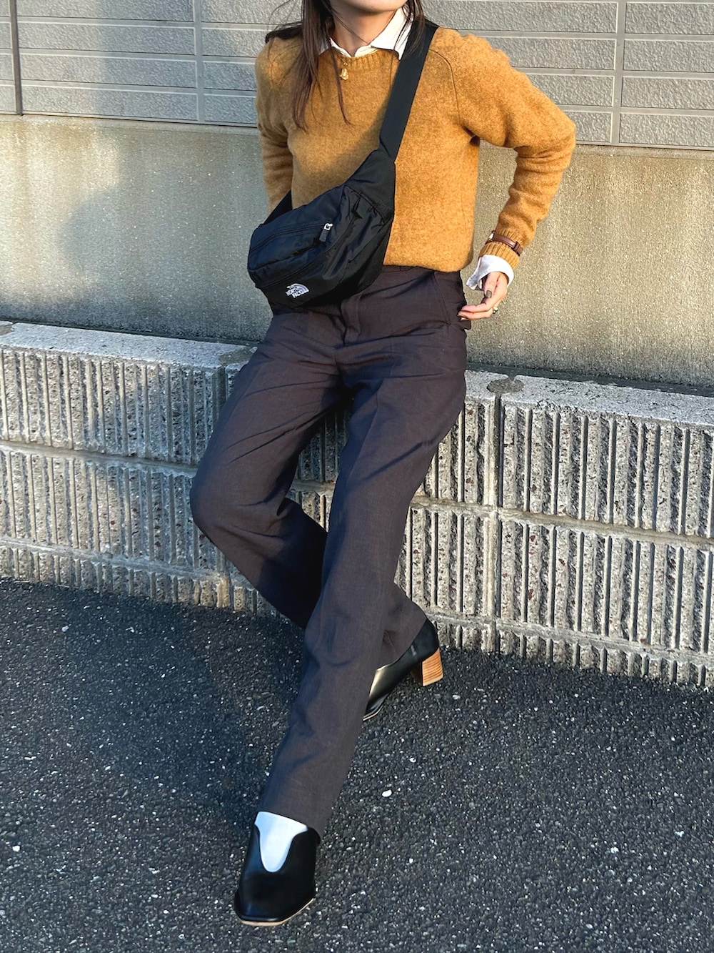 ブラック系のパンプス、グレー系のパンツ、ブラック系のボディバッグ/ウエストポーチを着用したレディースの秋コーディネートの3枚目の写真