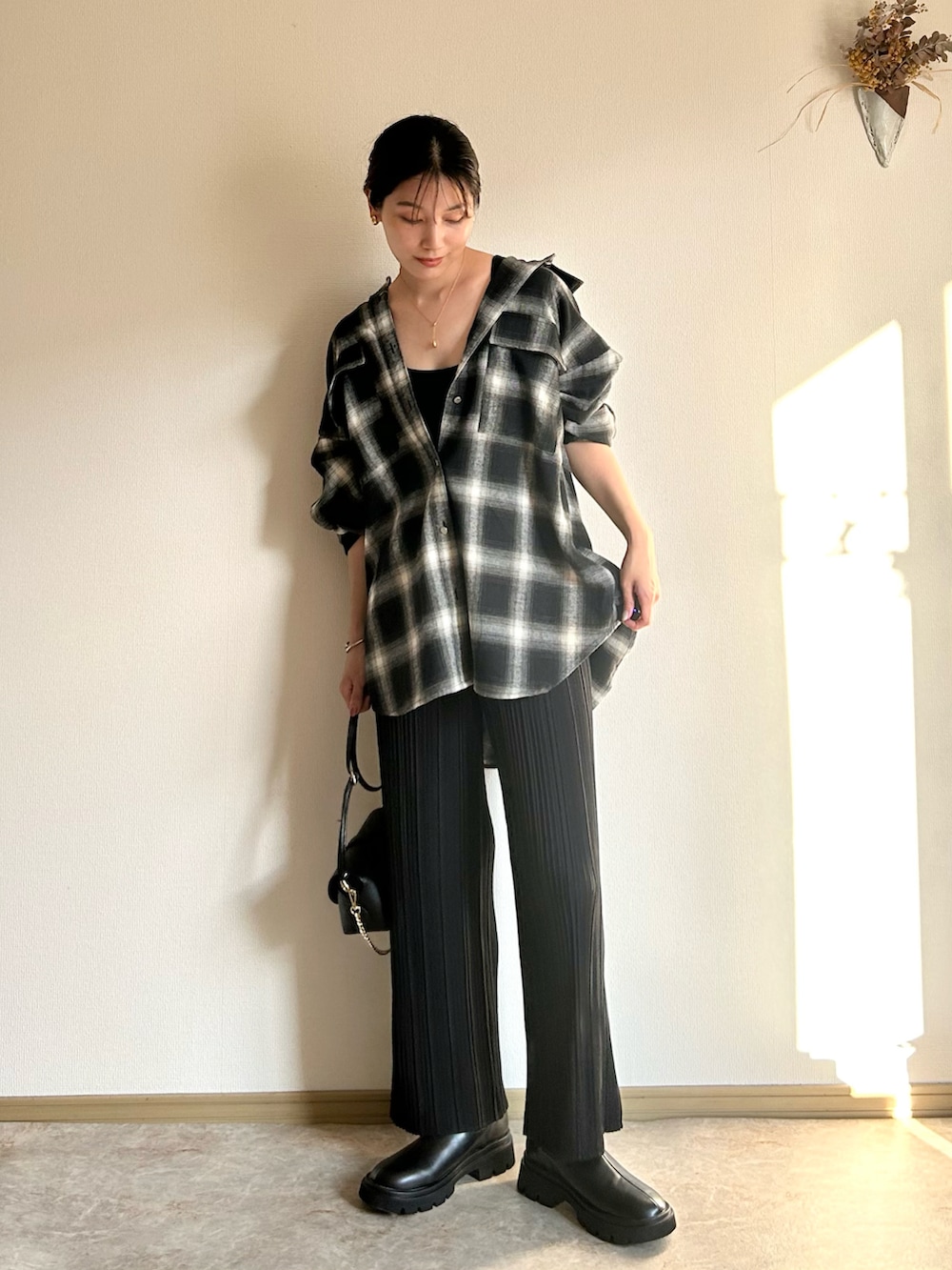 ブラック系のシャツ/ブラウス、ブラック系のブーツ、ブラック系のショルダーバッグを着用したレディースの夏コーディネートの2枚目の写真