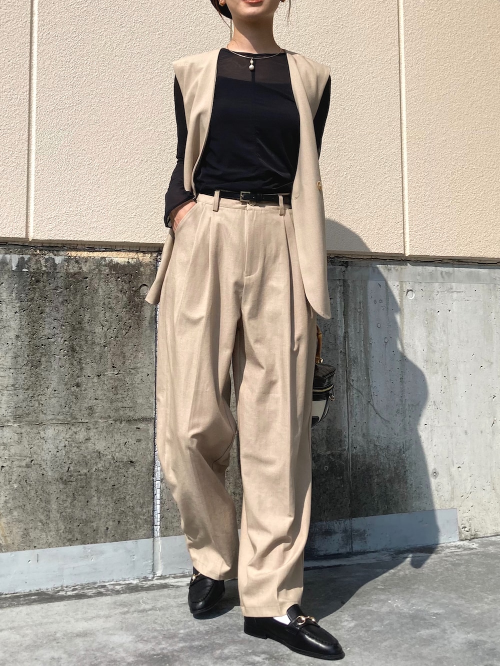 ベージュ系のセットアップ、ブラック系のローファー、ブラック系のTシャツ/カットソーを着用したレディースの秋コーディネートの2枚目の写真