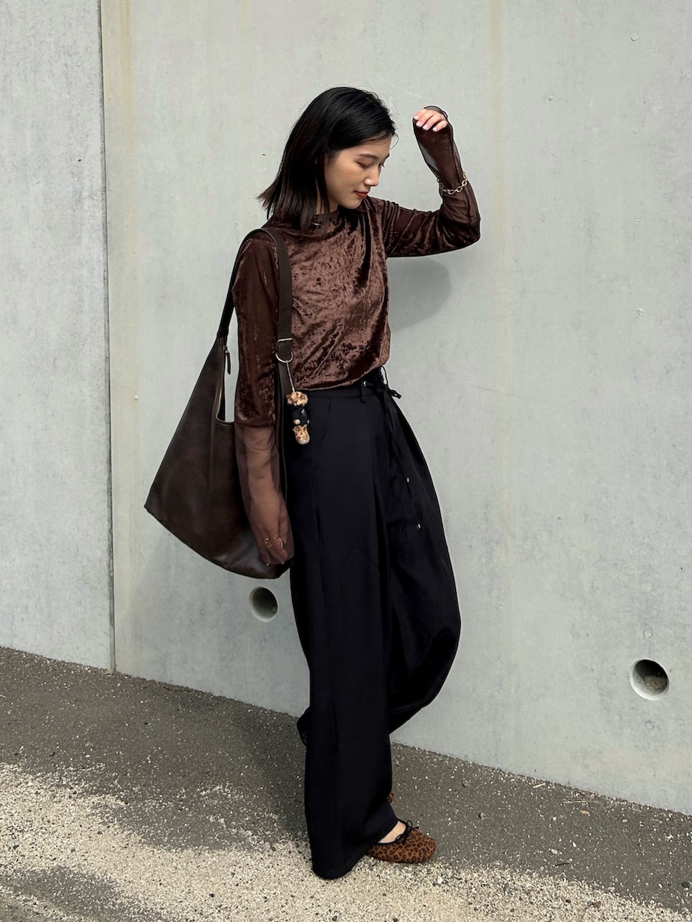 ブラック系のスラックス、ブラウン系のTシャツ/カットソー、ゴールド系のブレスレットを着用したレディースの秋コーディネートの5枚目の写真