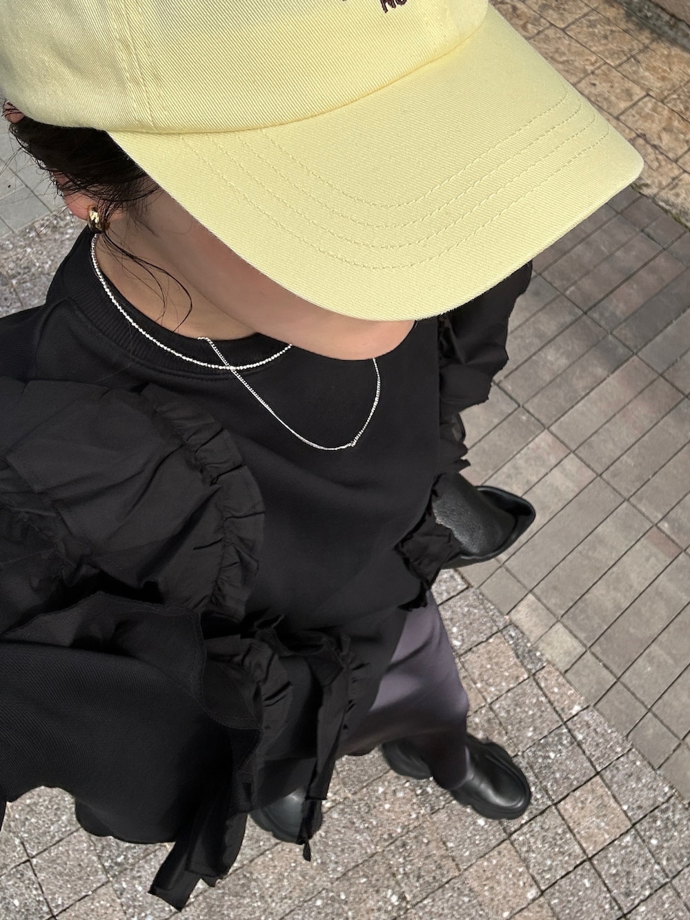 ブラック系のローファー、ブラック系のスウェット、ブラック系のハンドバッグを着用したレディースの春コーディネートの4枚目の写真