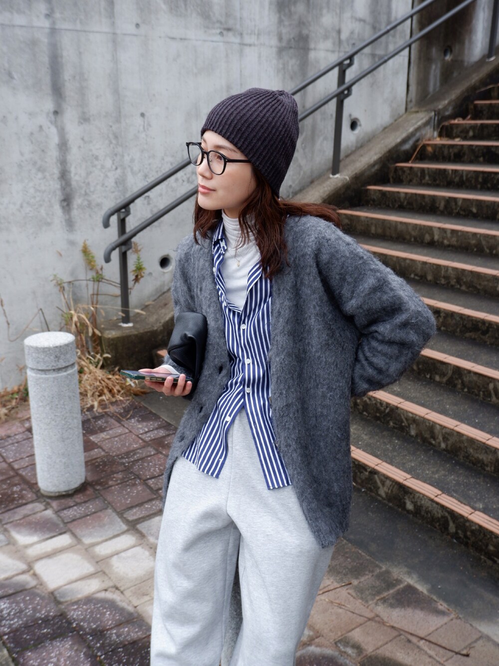 ブルー系のシャツ/ブラウス、グレー系のカーディガン/ボレロ、ブラック系のハンドバッグを着用したレディースの冬コーディネートの3枚目の写真